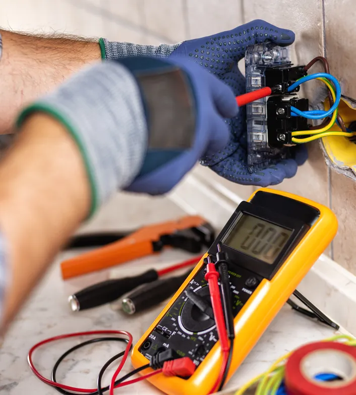 Electrician testing an outlet with a multimeter